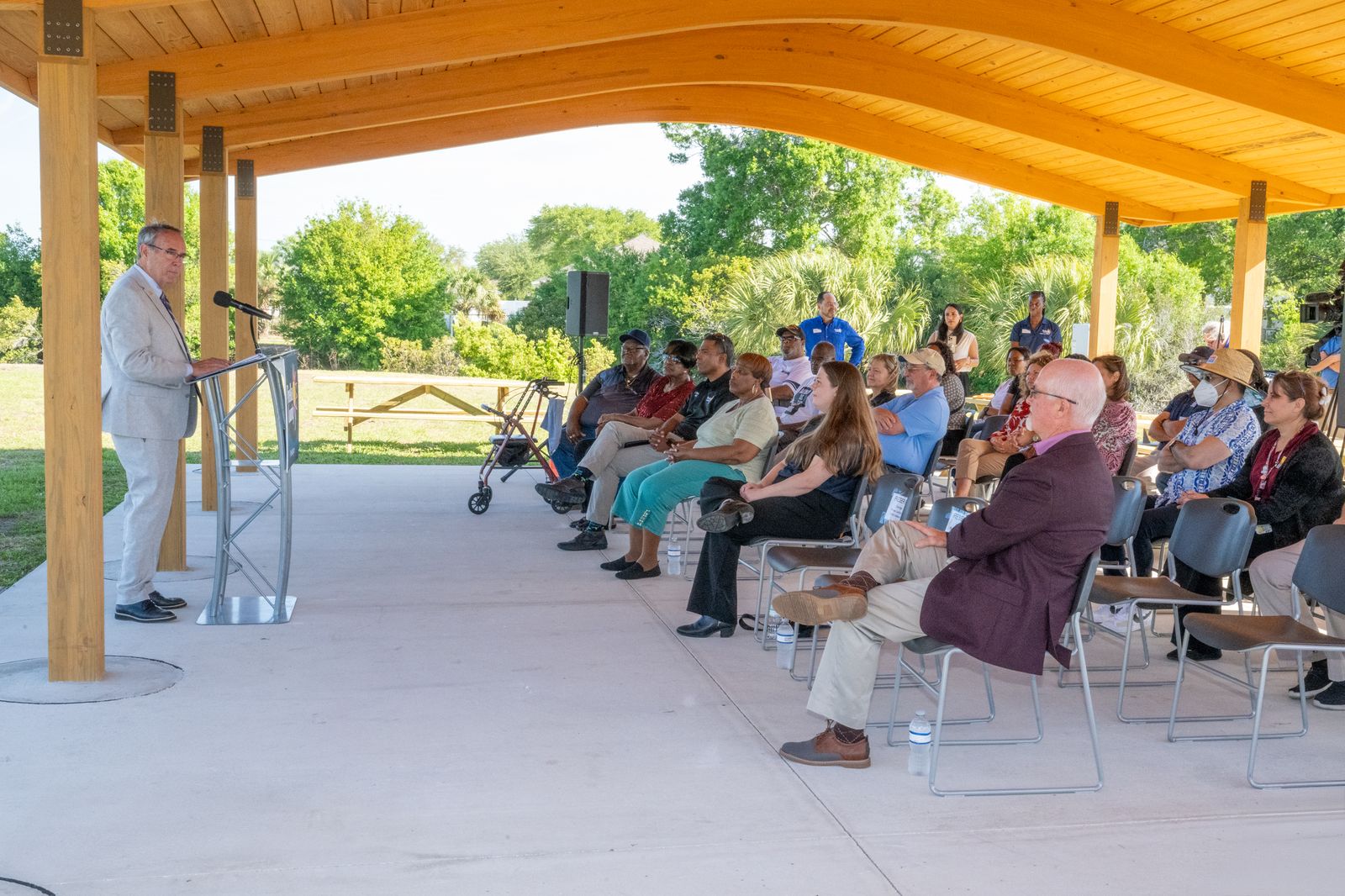 Dave Eggers speaking to community members at an outdoor pavilion meeting